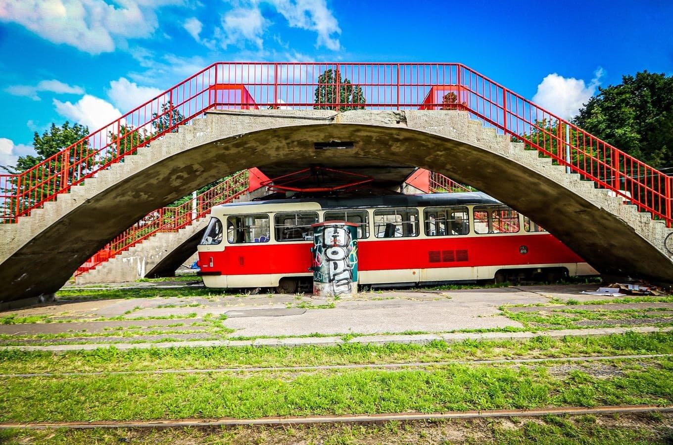 Betonový oblouk nadchodu nad odstavenou tramvají na smyčce Dlabačov